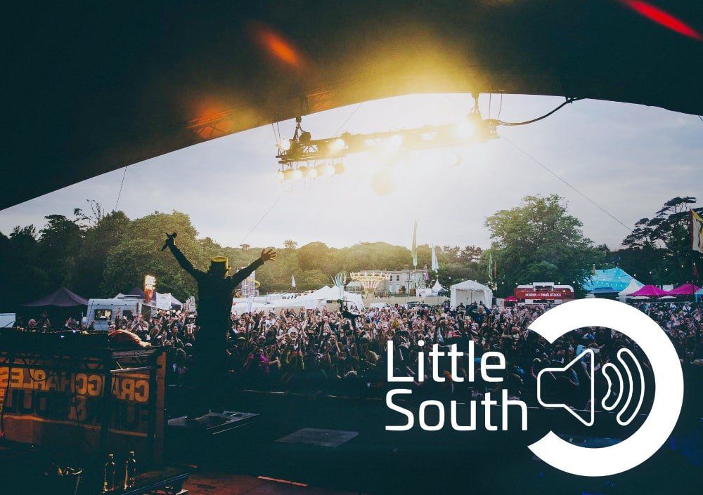 A man is standing in front of a crowd at a little south festival.