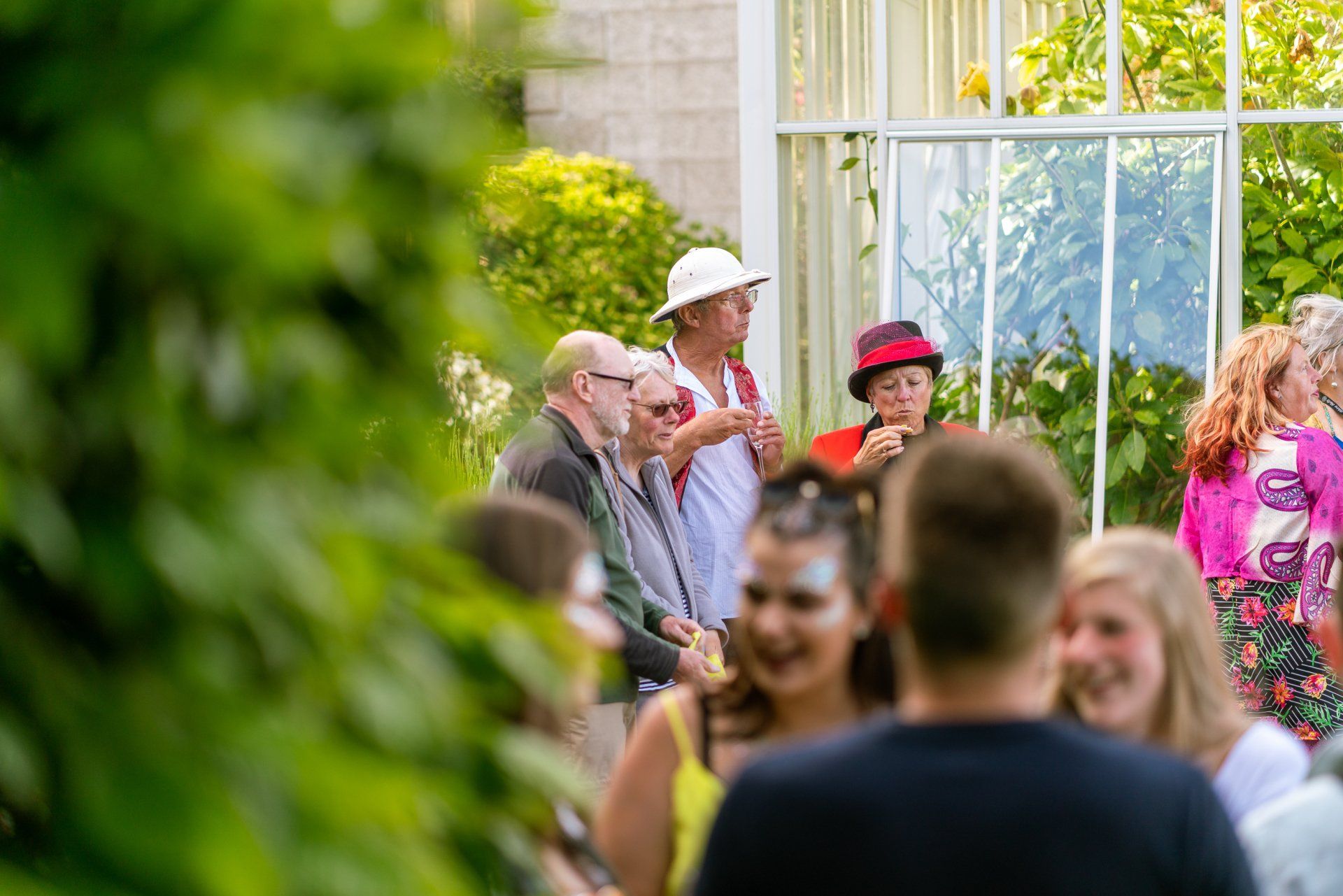 A group of people are standing in front of a greenhouse.