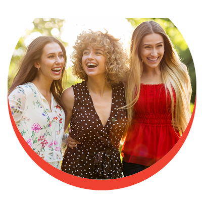 Three well groomed, friendly and good natured young woman are smiling exuberantly and standing closely together
