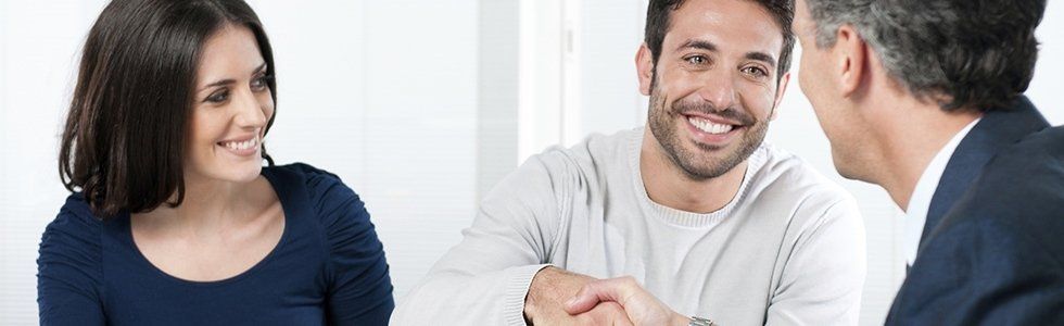 due uomini che si stringono la mano e una donna che li osserva