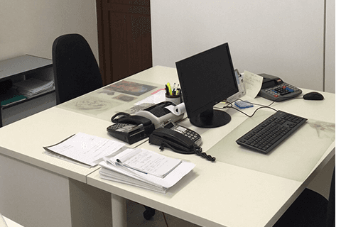 una scrivania con un monitor, un telefono e una tastiera