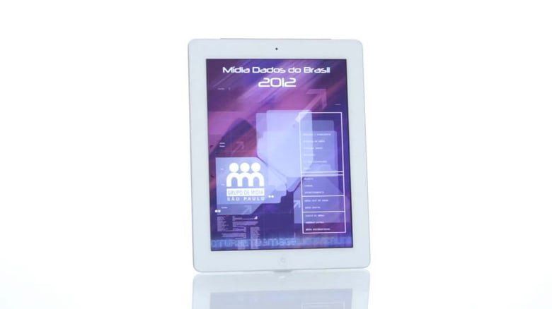 Um tablet branco com tela roxa está sobre uma superfície branca.