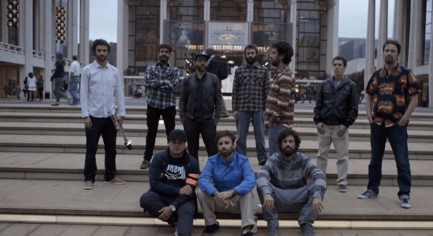 Um grupo de homens posa para uma foto em frente a um prédio.