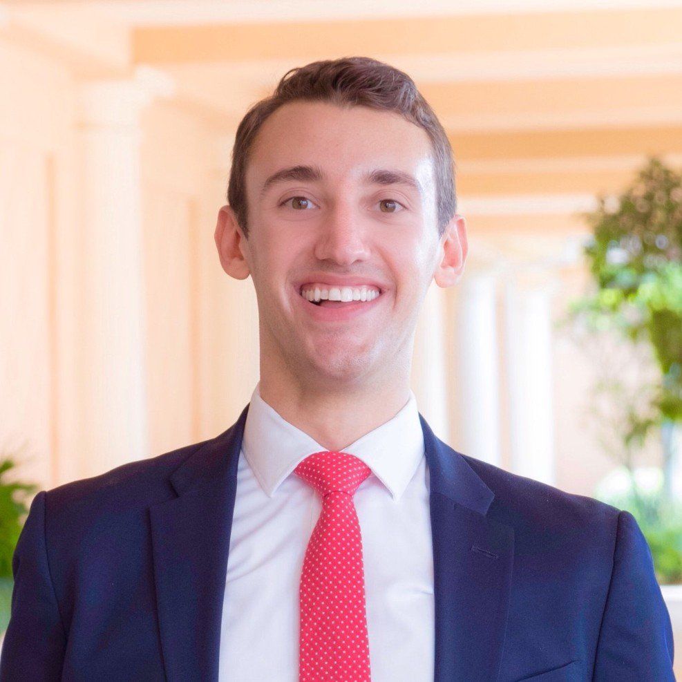 A man in a suit and tie is smiling for the camera.