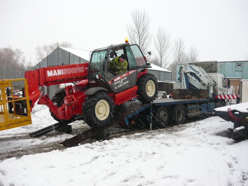lorry crane carrying tractor at snow filled region