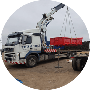 lorry crane moving a small red container