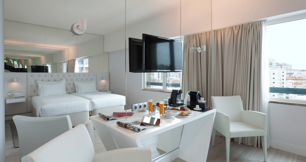 Um quarto de hotel com uma mesa, cadeiras e uma cama.