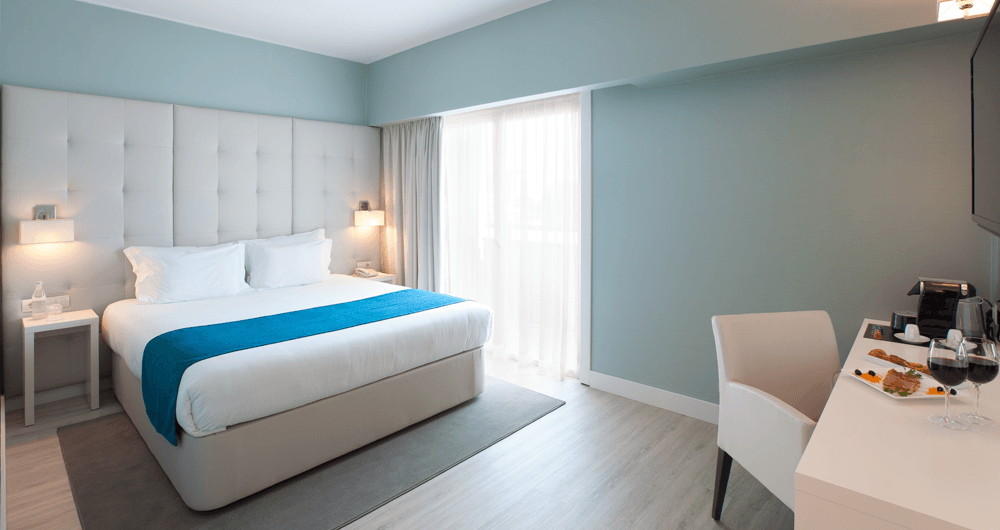 Um quarto de hotel com uma cama king size e uma escrivaninha.