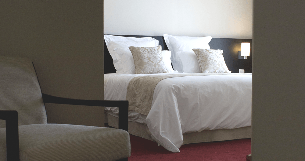 Um quarto de hotel com uma cama e uma cadeira