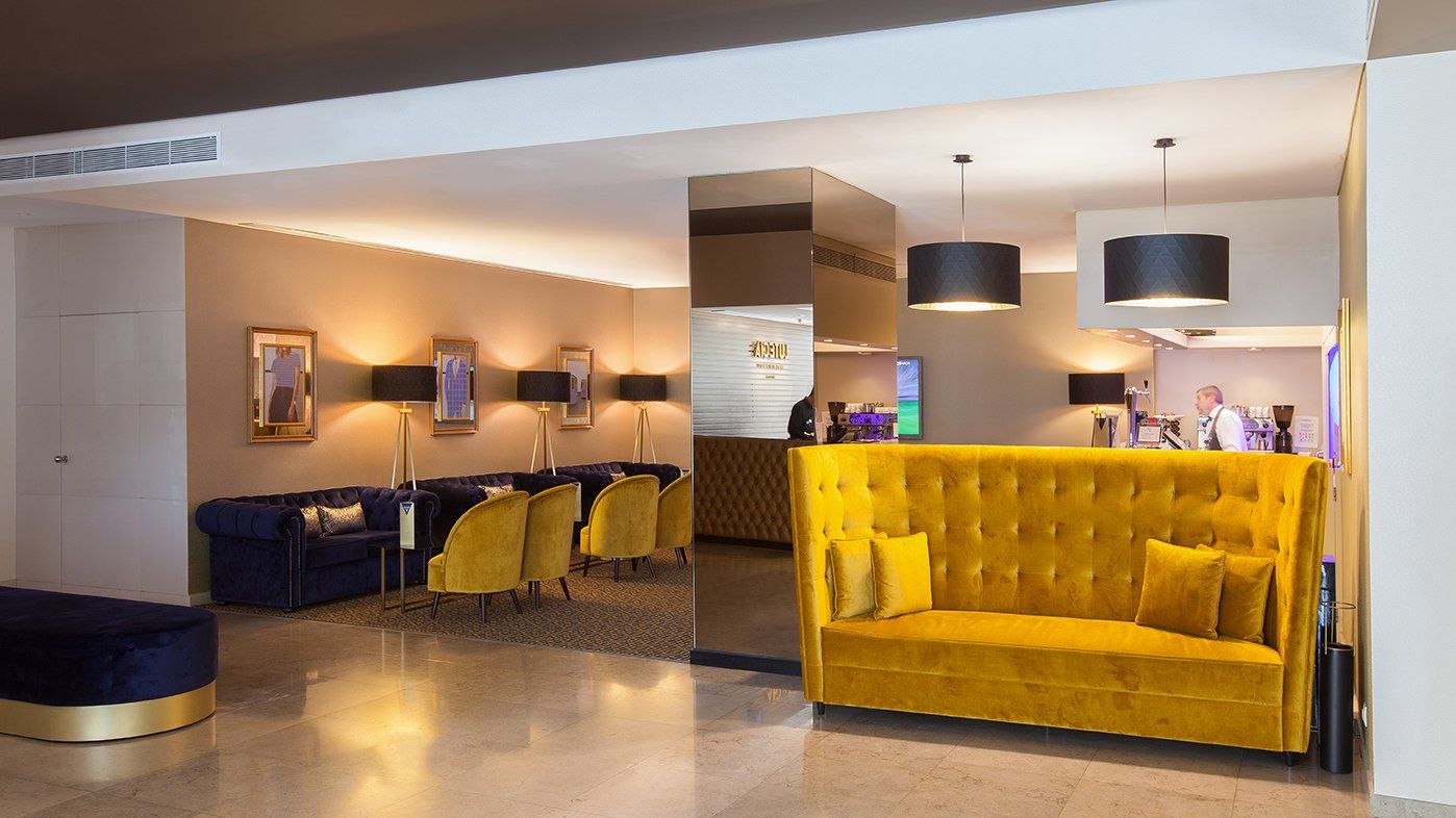 Um lobby de hotel com um sofá amarelo e sofás azuis