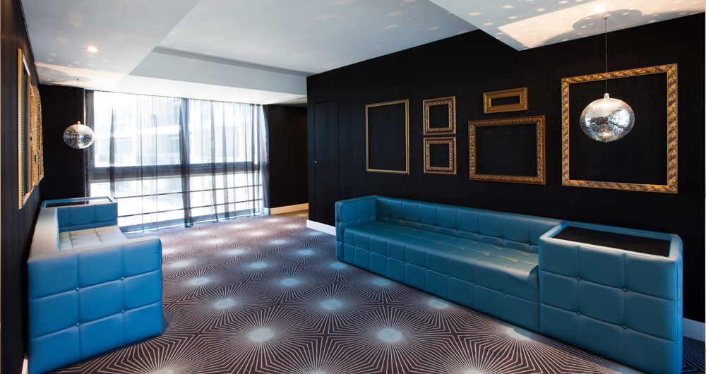 Uma sala de estar com um sofá azul e duas cadeiras azuis