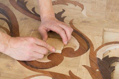 Craftsman installing parquet Hammer and nails on floor