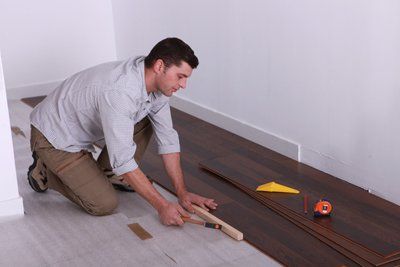 Worker putting wood flooring Worker putting wood flooring