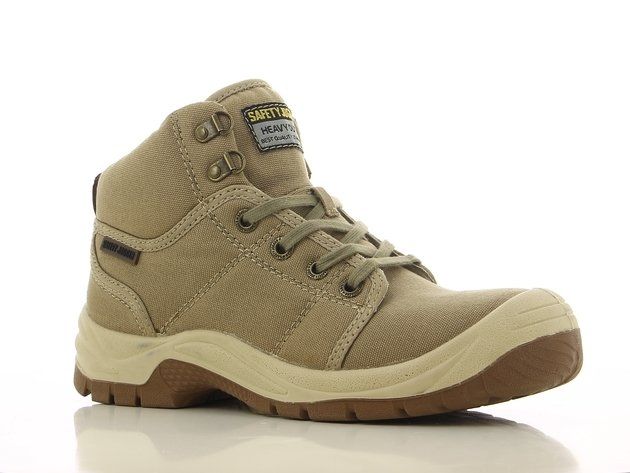 A pair of tan safety boots are sitting on a white surface.