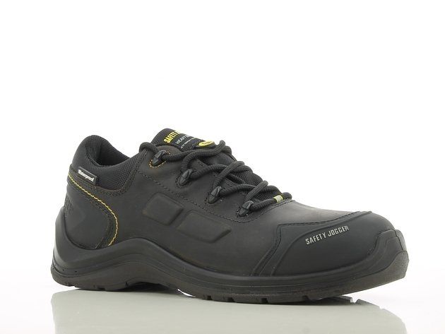A pair of black and yellow safety shoes on a white surface.