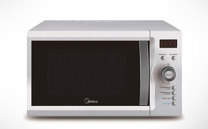 A microwave oven is sitting on a white surface.