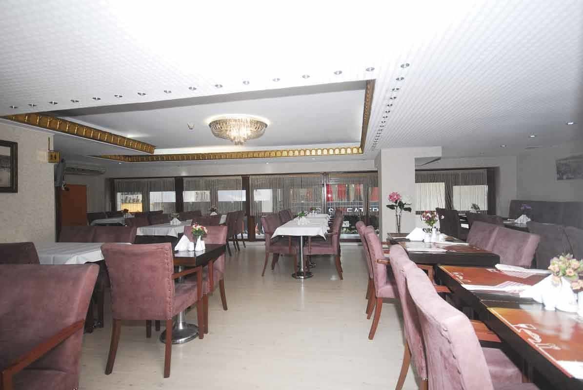 A restaurant with tables and chairs and a ceiling light