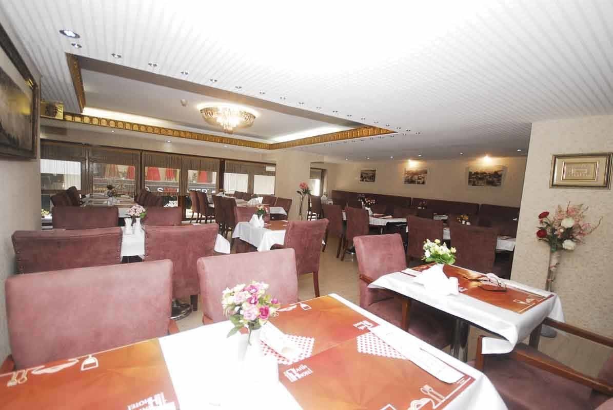 A dining room with tables and chairs and flowers on the table