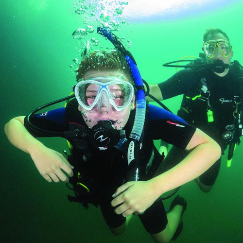 Two scuba divers underwater, one in focus.