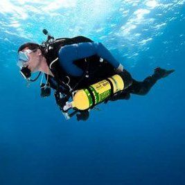 Scuba diver in blue water, wearing a mask and gear, with a yellow oxygen tank.
