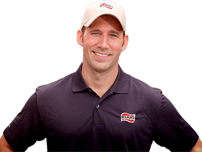 A smiling person wearing a dark blue polo shirt and a light-colored baseball cap with a company logo.