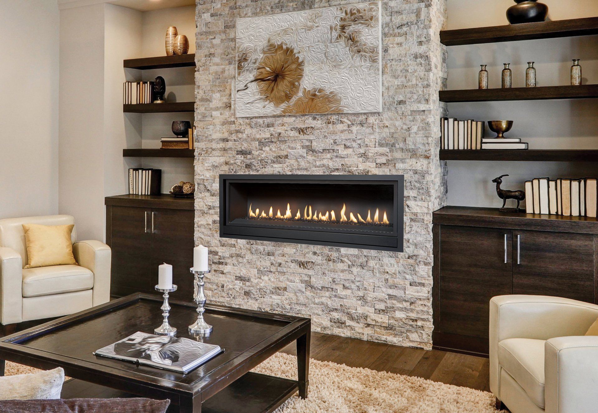 Living room with fireplace, stone wall, built-in shelves, modern furniture, and a rug.