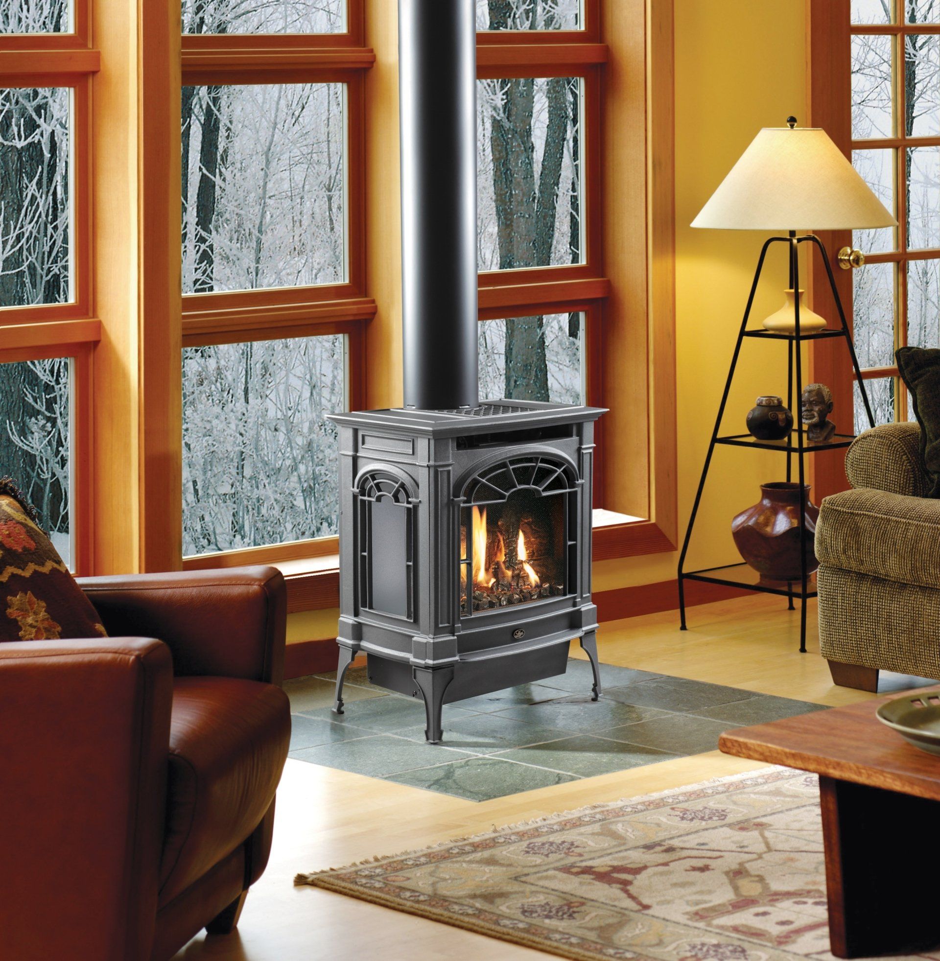 Gas fireplace in living room with large windows, dark pipe, and reading lamp.