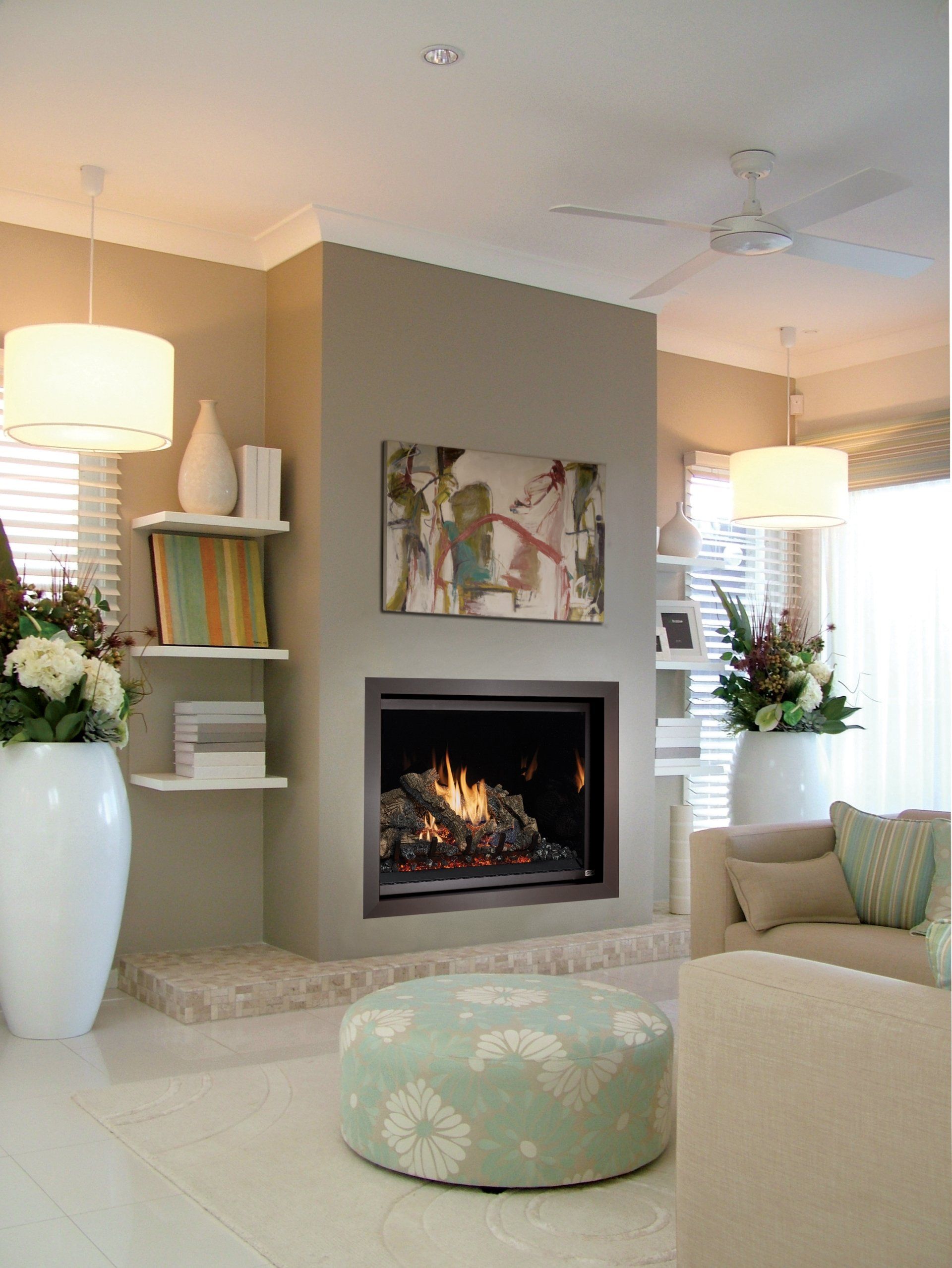 Cozy living room with fireplace, neutral tones, modern art, and large white vases.