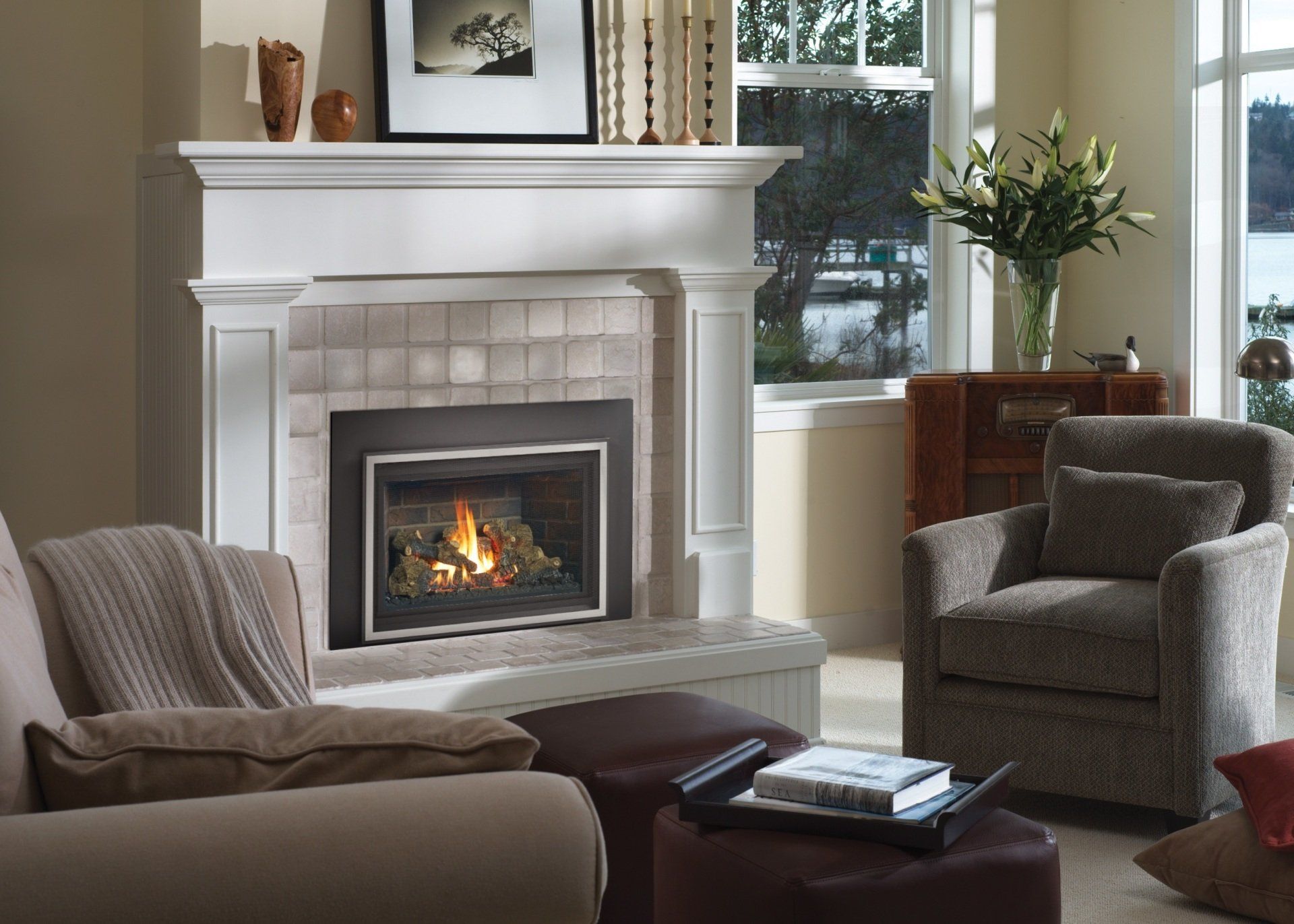 Living room with a fireplace, beige walls, and a view of a lake through a window.