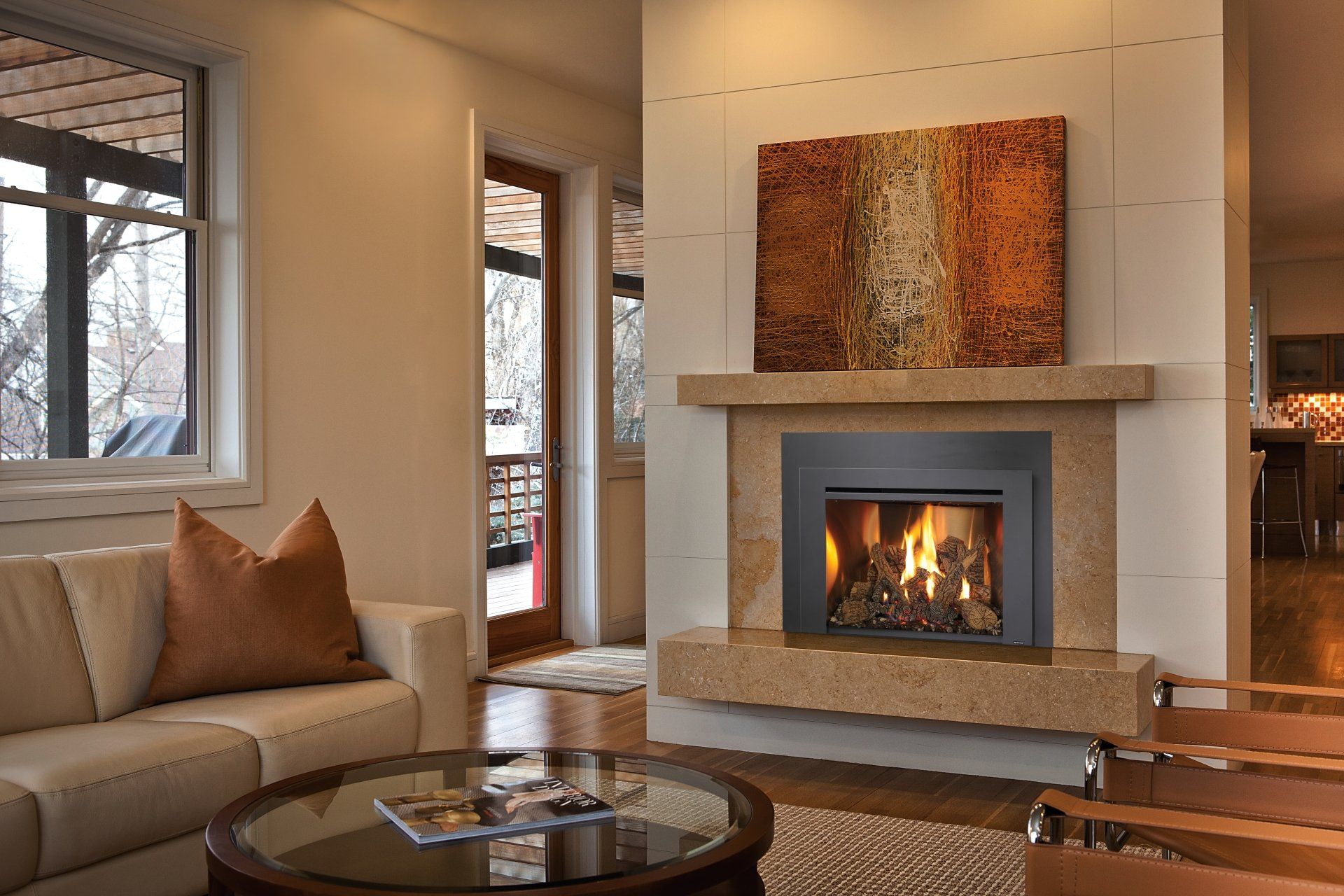 Living room with fireplace, beige sofa, round coffee table, and abstract art above.