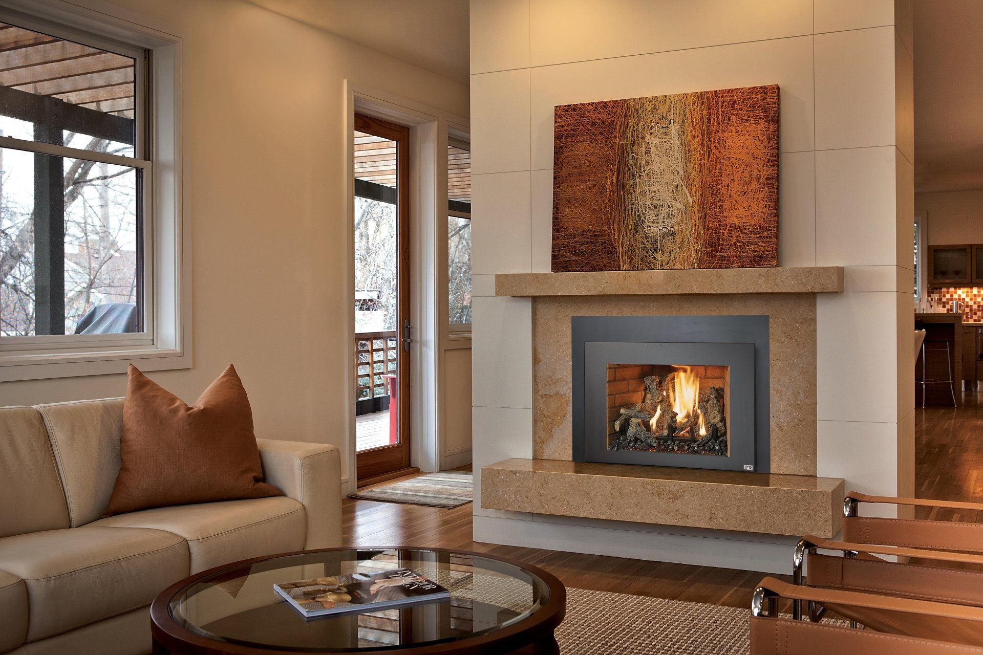 Cozy living room with fireplace, beige sofa, round coffee table, and abstract art above.