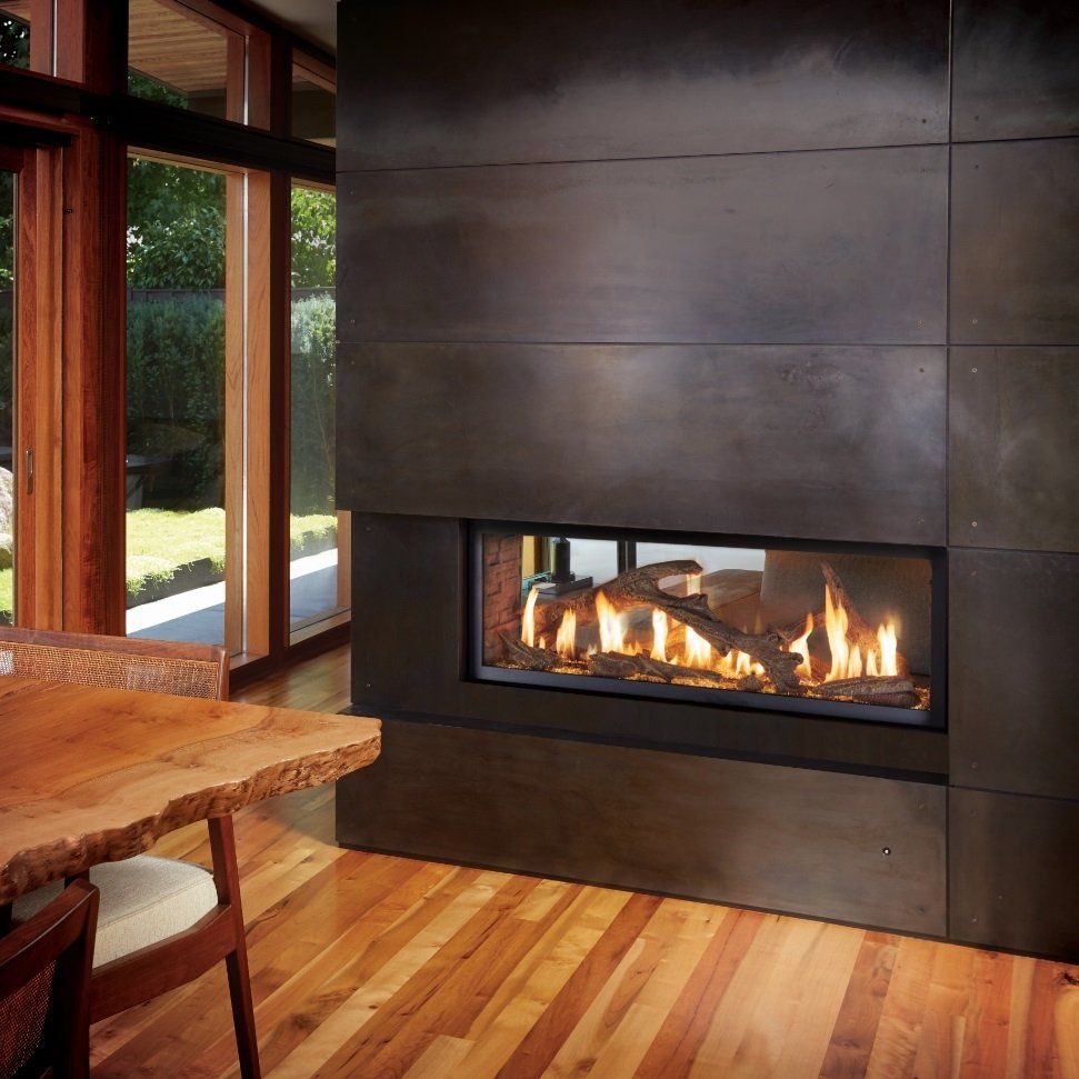 Modern fireplace with flames, wood floor, and wooden table near a window.