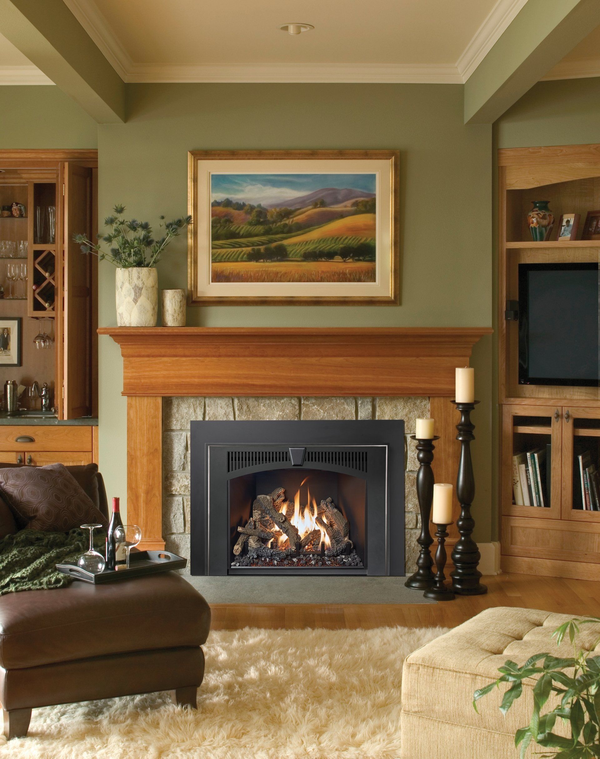 Living room with fireplace, wooden mantel, stone facade, painting above.