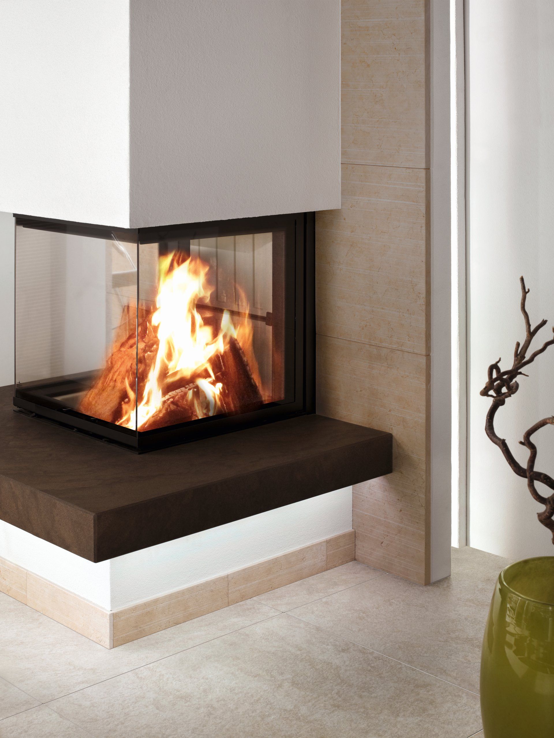 Modern fireplace with fire, glass enclosure, and stone surround.
