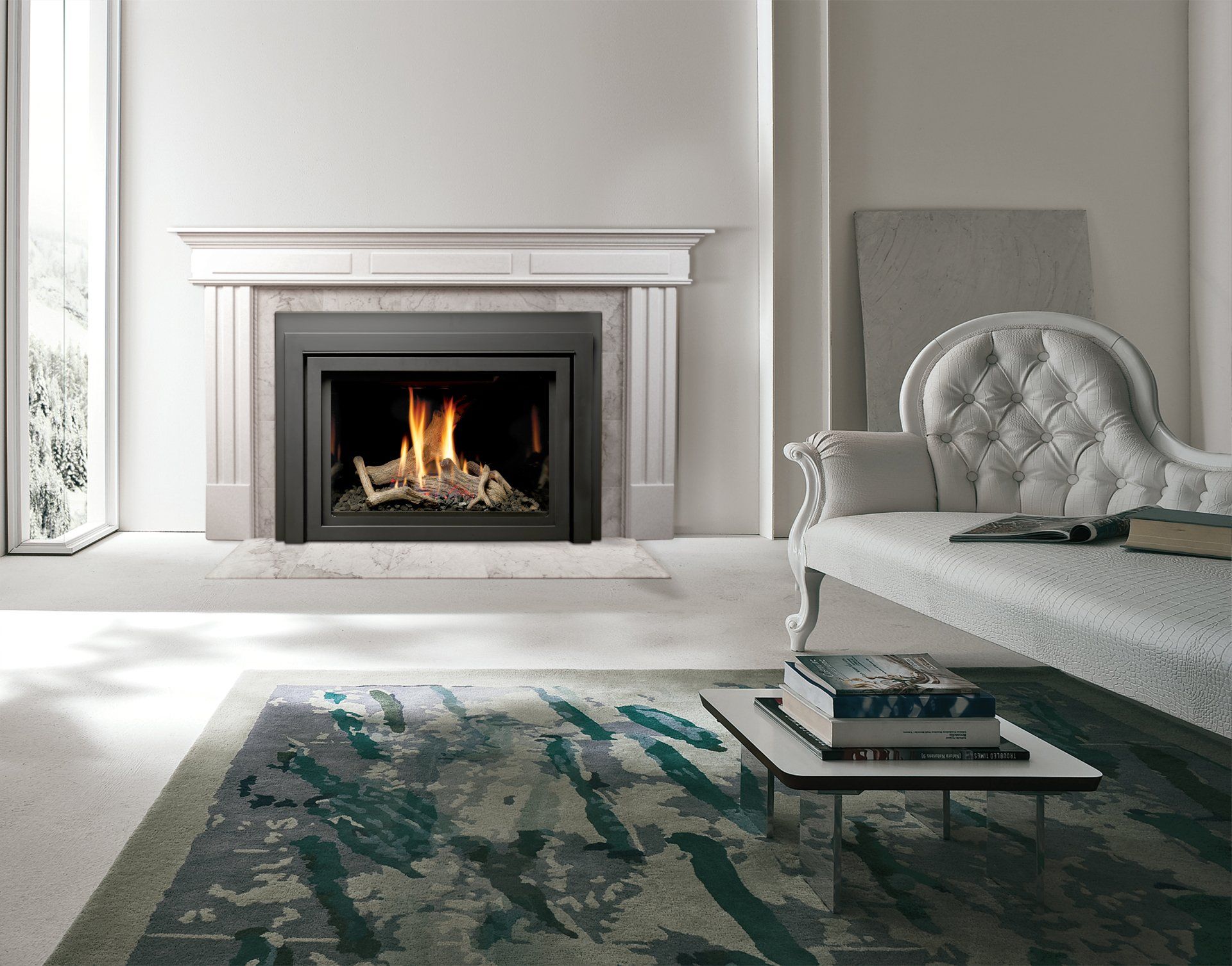 Fireplace with flames in a modern white room; a couch and coffee table with books are nearby.