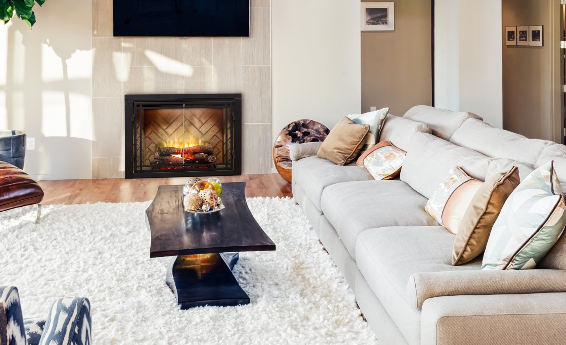 Living room with fireplace, white rug, gray sectional sofa, coffee table, and decorative pillows.