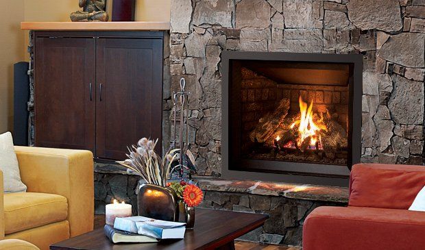 Fireplace with stone surround, lit flames, dark brown frame, adjacent brown cabinet, and orange and yellow couches.