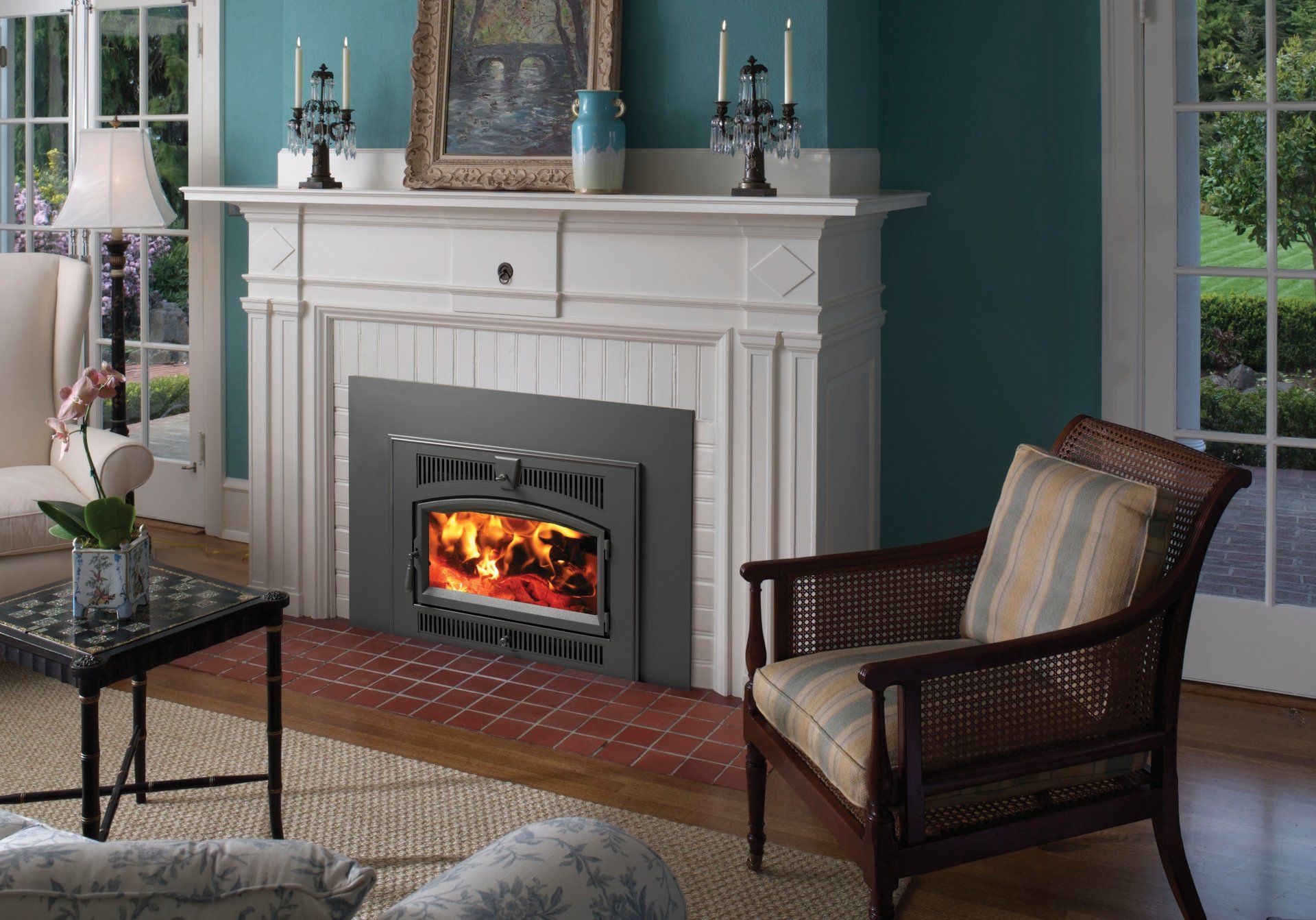 Fireplace insert in a white mantel with a seated wicker chair in front.