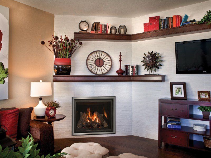 Cozy living room corner with fireplace, built-in shelves displaying decor, a TV, and a brown sofa.
