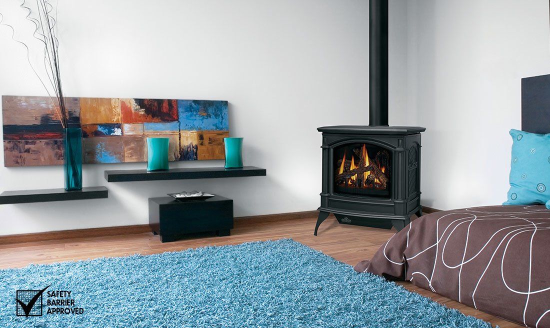 Cozy room with a black fireplace, blue rug, and modern art on a white wall.