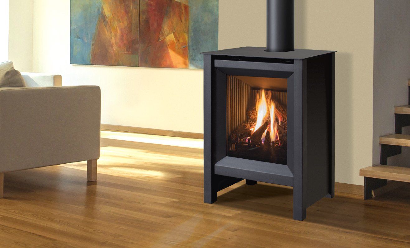 Black fireplace with lit flames in a living room with wooden floors, a couch, and artwork.