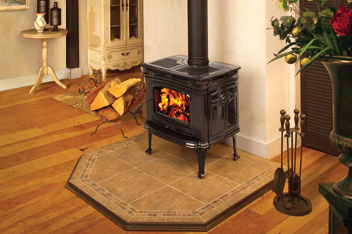 Wood-burning stove with flames, surrounded by wooden floor, tiles, and a metal fire tool set.