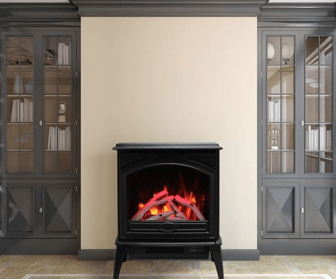 Black electric fireplace centered against a cream wall, flanked by gray cabinets.