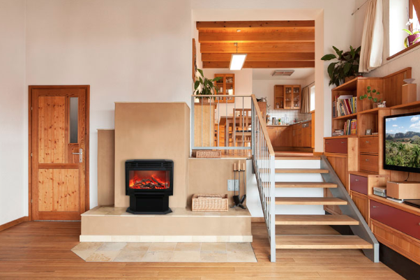 Interior with fireplace, staircase, and open kitchen in a modern home.