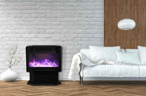 Black electric fireplace with purple flames in a living room next to a white couch.
