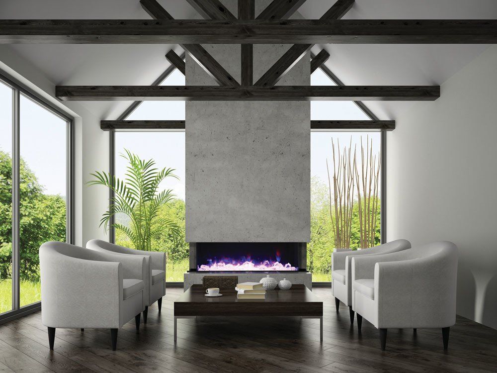 Modern living room with fireplace, white chairs, and large windows with a view of greenery.