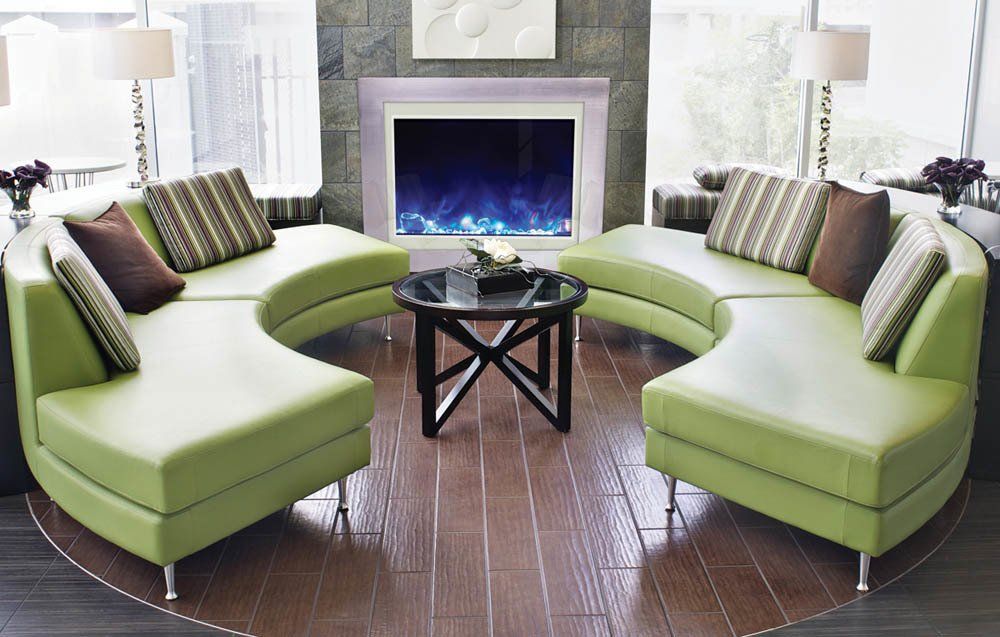 Lime green curved sofas surround a small table near a fireplace.