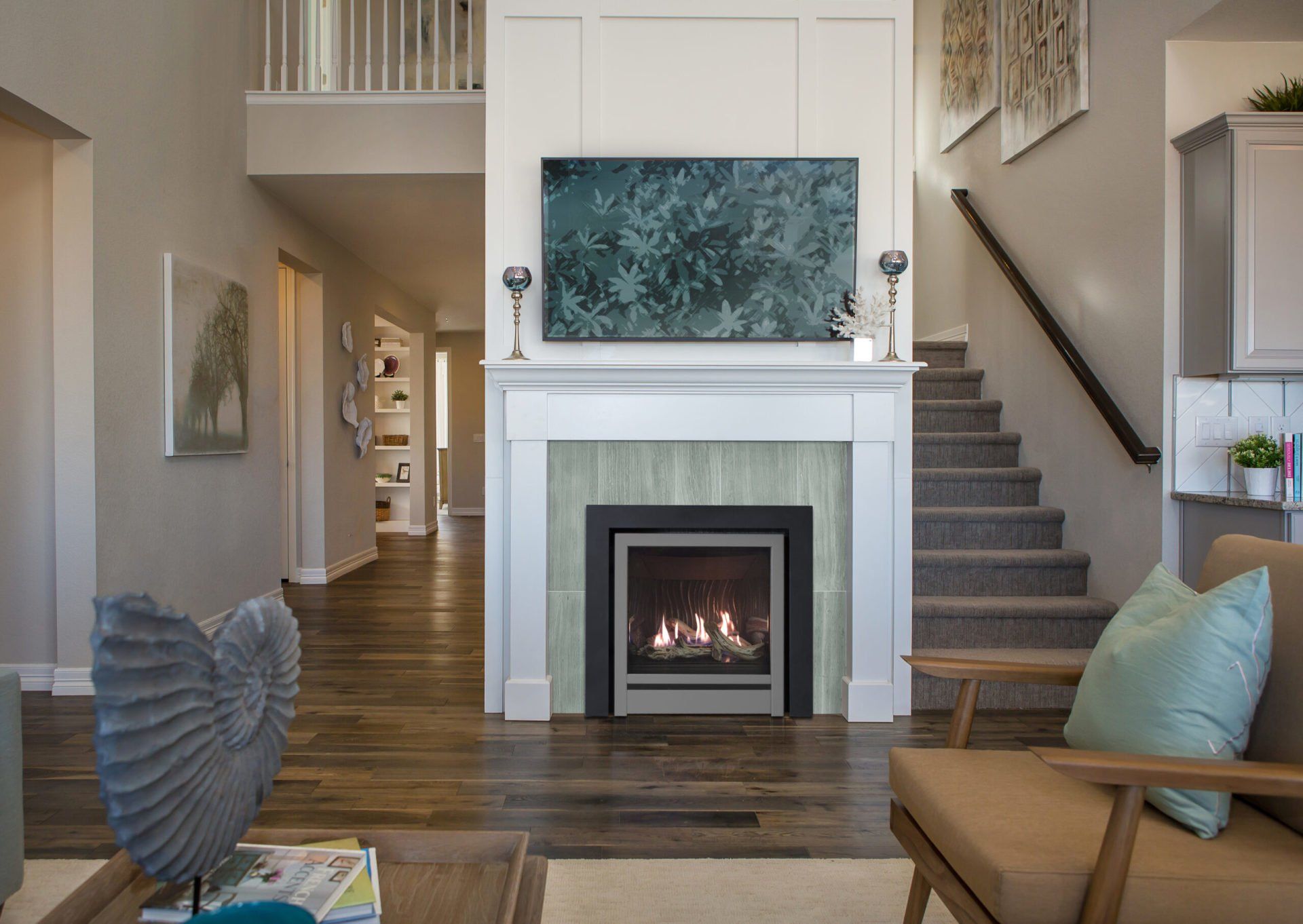 Living room with fireplace, artwork, stairs, and furniture in a home.