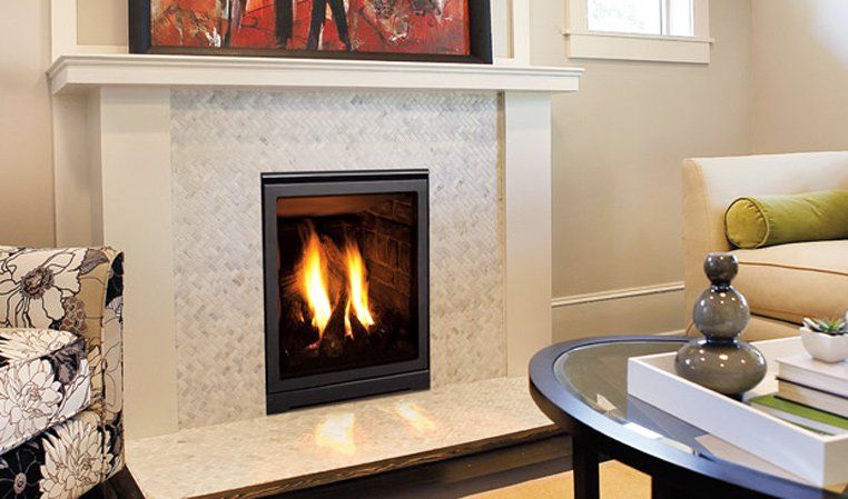 Fireplace with flames, framed by marble and a white mantel, in a living room.