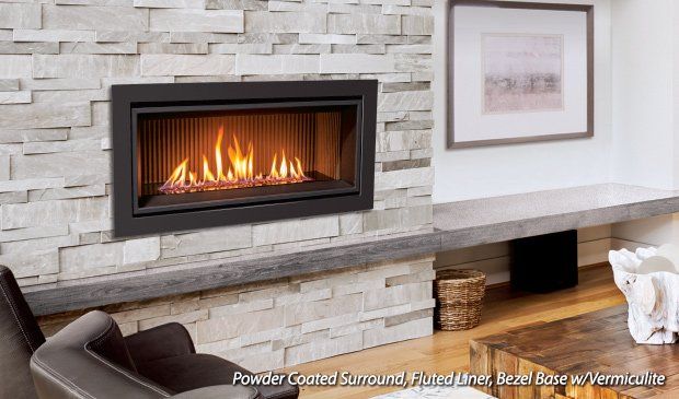 Modern fireplace with flames in a black frame, mounted on a stone wall.